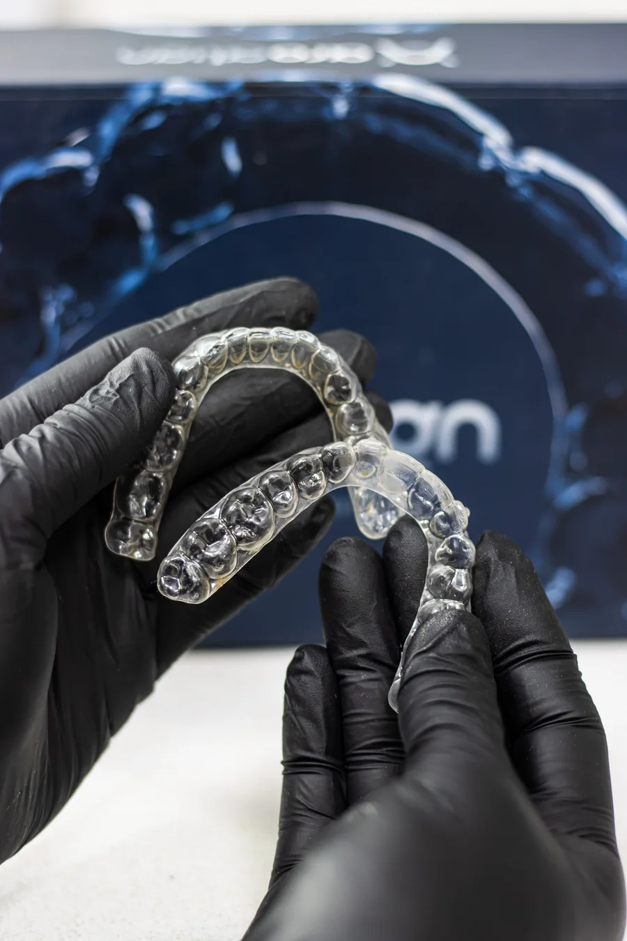 Alineador transparente sostenido con guantes en el consultorio